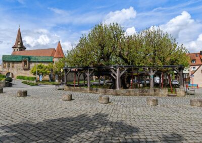 Tanzlinde Effeltrich: gleich gegenüber auf der anderen Straßenseite die eindrucksvolle Wehrkirche des Ortes