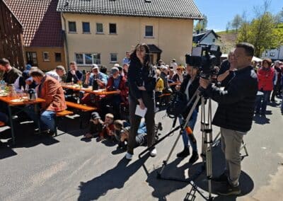 Ausrufung Dorflinde Harbach: Das ZDF hat über 3 Stunden gedreht, und die auf dem Asphalt liegenden Kinder staunen den Baum an – herrlich!